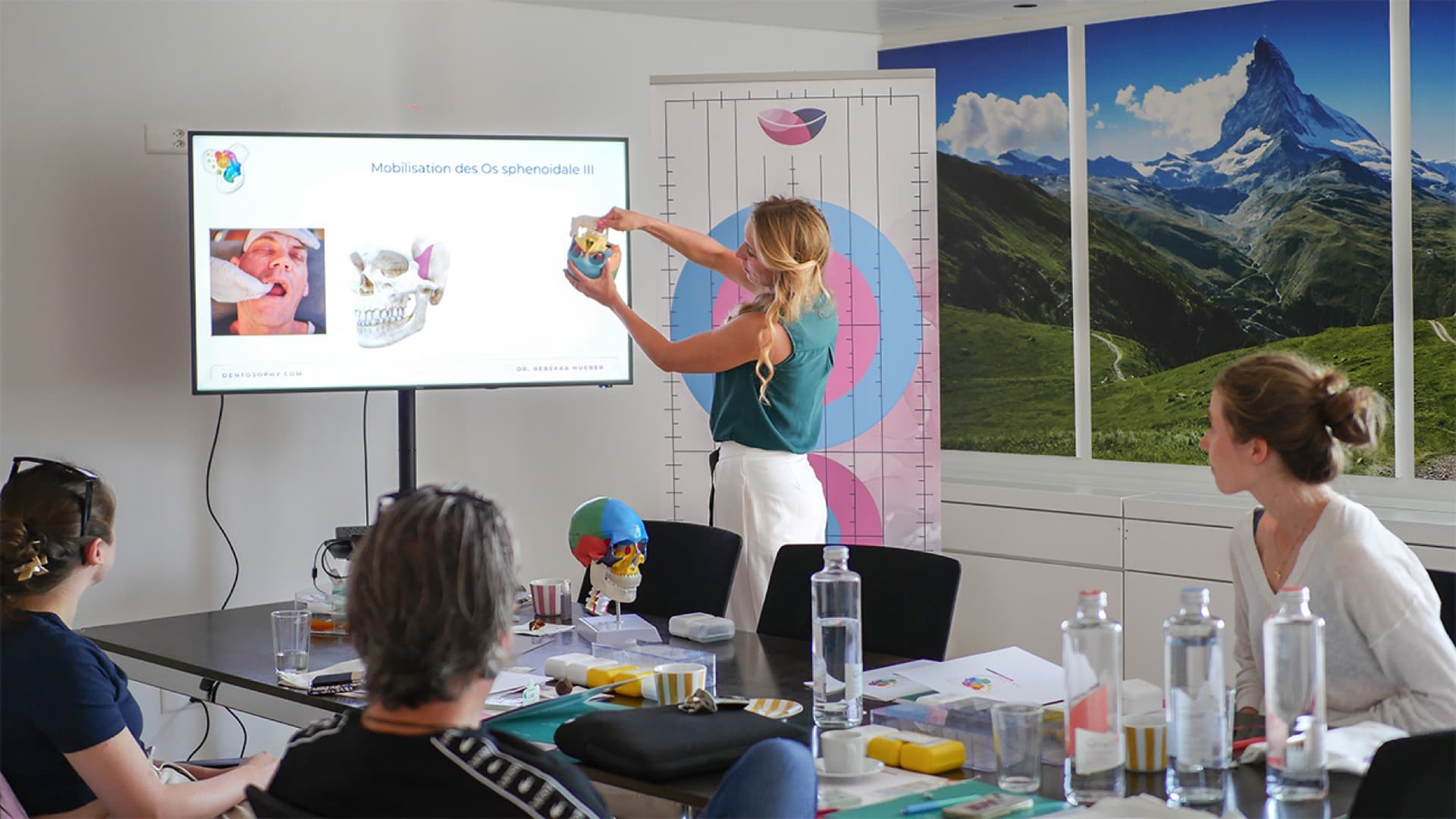 Workshop scene: Dr. med. dent. Rebekka Hueber explaining the craniofacial system on a model to participants
